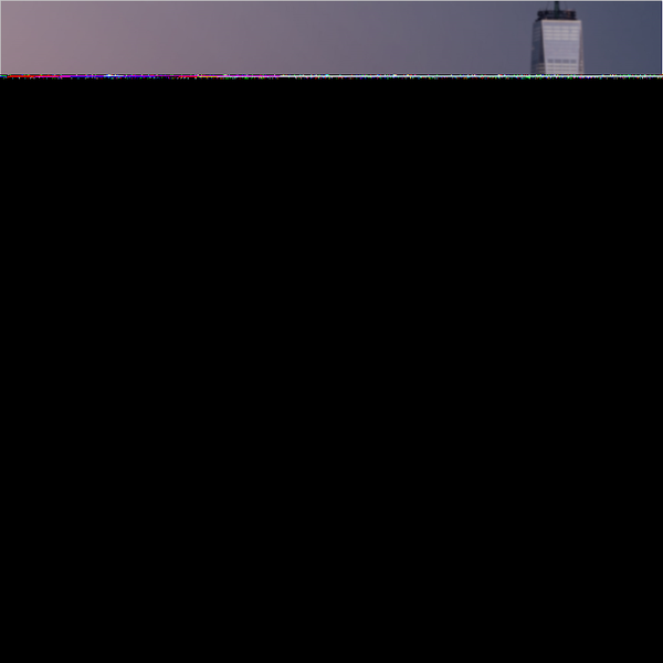Skyline silhouette featuring a tall building against a colorful dusk sky.